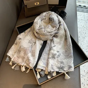 Detailed view of floral cotton linen scarf with elegant tassel edges on a display tray