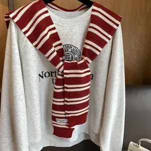 Red striped knitted shawl draped over a grey Northwestern University graphic sweatshirt