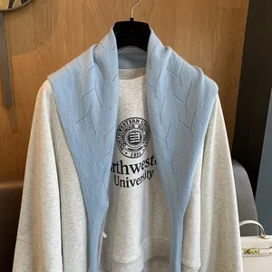 Détail d'un châle en laine bleu clair avec motif à losanges et texture tricotée