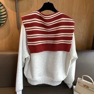 Chic red striped knitted shawl paired with a minimalist cream sweater for autumn fashion