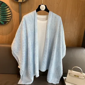 Light blue striped sun protection shawl with gold foil accents on a hanger