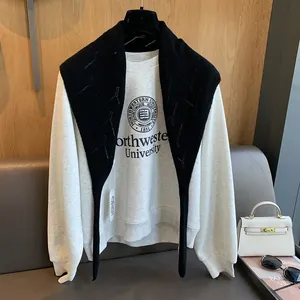Détail d'un châle en laine tricotée noire sur un sweat gris pour un style décontracté