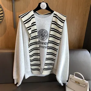 Detail showing red and white striped knit shawl accessory styled over a casual grey sweatshirt