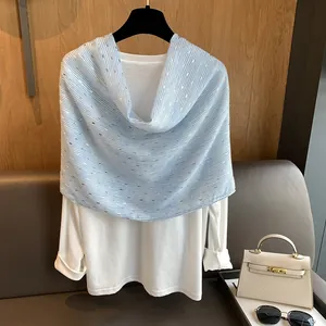 Blue and white striped scarf with gold foil accents draped over a white shirt