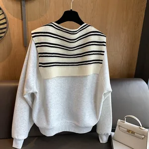Detail of grey sweatshirt with decorative black and white striped knitted navy collar