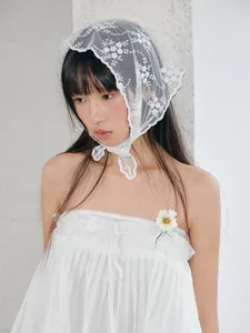 Detailed view of white floral lace headscarf with delicate embroidered edges