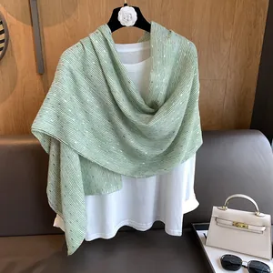 Close-up of thin striped linen scarf with gold metallic thread on a white t-shirt