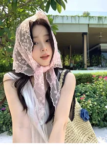Close-up of pink floral lace headscarf with embroidery and matching straw bag