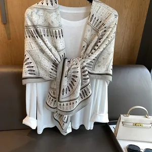 Detail view of ethnic feather prints on a lightweight bohemian wrap scarf