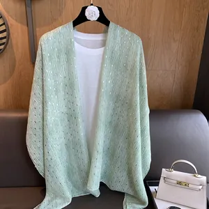 Detail of light green thin shawl with vertical gold stripes and subtle sequins decoration