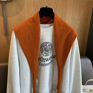 Gros plan sur le châle en tricot orange vif avec motifs ajourés géométriques