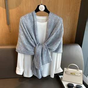 Detail of blue and white striped scarf with silver polka dots on a black clothes hanger