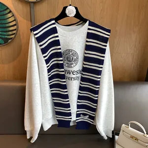 Detailed knit striped shawl draped over a university logo sweatshirt for women