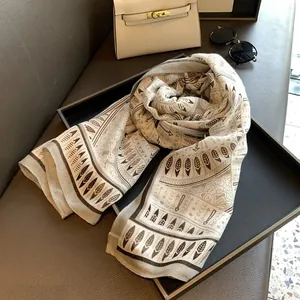 Detailed view of ethnic print scarf featuring beige and dark brown geometric feather patterns