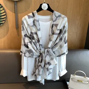 Detail of geometric abstract pattern scarf with lightweight texture in white and coffee