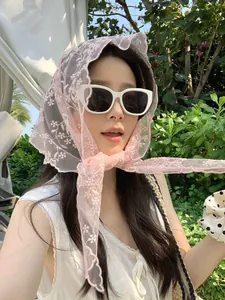 Close-up of pink floral lace headscarf with white sunglasses and polka dot hair tie