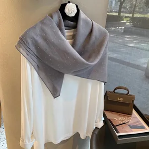 Vue détaillée d'une écharpe en lin gris avec strass et haut blanc élégant assorti