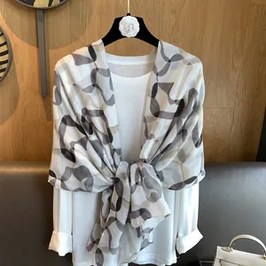Close-up of lightweight scarf with abstract geometric patterns and silky texture