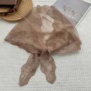 Detailed flat lay of brown lace triangular scarf with intricate floral embroidery decoration