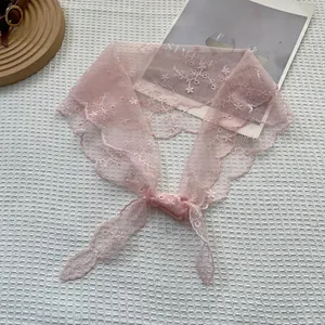 Close-up of pink lace headscarf with delicate floral embroidery and scalloped edges