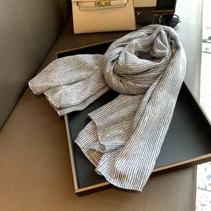 Detail of blue and white striped cotton scarf with golden sparkle accents on a tray