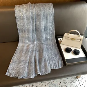 Detail of blue and white striped linen scarf with gold foil dots on a leather chair