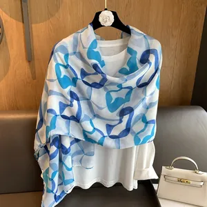 Macro detail of lightweight blue heart print scarf styled over a white long-sleeve top