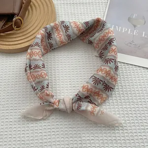 Détail d'un foulard en soie à fleurs bohèmes sur fond de tissu gaufré blanc