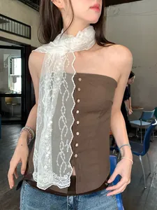 Detail of elegant white lace floral scarf with embroidery on a retro brown vest
