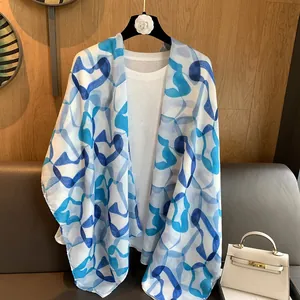 Detail view of lightweight blue and white geometric print shawl on a decorative hanger