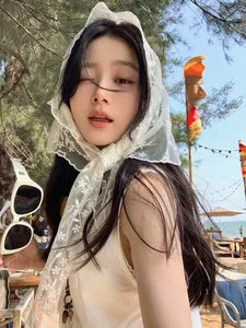 Outdoor close-up of white floral lace headscarf styled with retro sunglasses and sundress