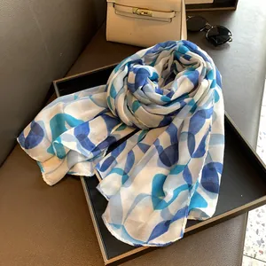 Detailed view of lightweight blue geometric floral scarf with fine stitched edges