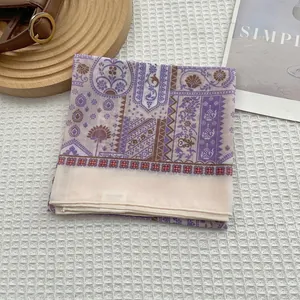 Detail of baroque print linen square scarf with delicate rolled edges on a rustic tray