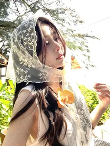 Detailed view of semi-transparent floral lace headscarf with delicate embroidery