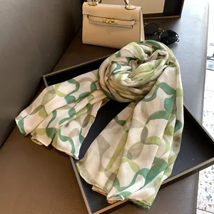 Detailed view of light green geometric print scarf roll with fine rolled edges in a tray