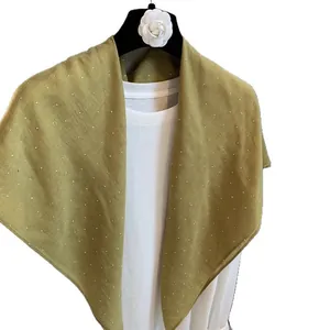 Châle en coton et lin jaune moutarde avec strass sur un t-shirt blanc sur cintre