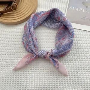Detail of bohemian floral print square scarf in purple pink tied on a leather bag strap