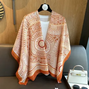 Close-up of ethnic orange and white solar geometric patterns on a soft chiffon shawl