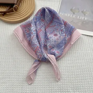 Flat lay of pink paisley cotton linen square scarf with wooden tray and leather bag