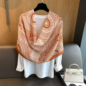 Detail of bohemian scarf featuring orange and tan ethnic patterns with feather motifs