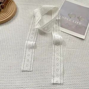 Detail of white lace scarf showing intricate floral patterns and geometric eyelets