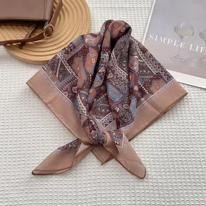 Détail d'un foulard en soie bohème à fleurs sur un tissu gaufré blanc élégant
