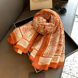 Detail of tropical tribal print scarf in orange and beige with lightweight silk texture