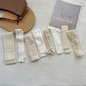 Elegante collezione di sciarpe in pizzo bianco con ricami floreali su sfondo di tessuto
