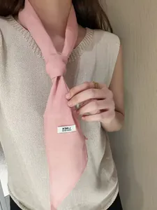 Close-up of pink linen neck scarf showing natural fiber texture and hand made label
