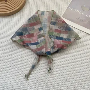 Détail d'un foulard léger à fleurs et carreaux montrant les motifs et l'ourlet ondulé