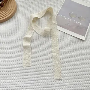 Detail of cream white lace scarf featuring intricate floral embroidery and vintage aesthetic