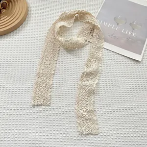 Close-up of beige floral lace scarf with delicate hollow embroidery and sunflower patterns