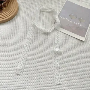 Detailed macro view of white floral lace scarf with elegant hollow embroidery pattern