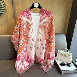 Détail d'un châle à fleurs roses avec pompons décoratifs et tenue de voyage stylée